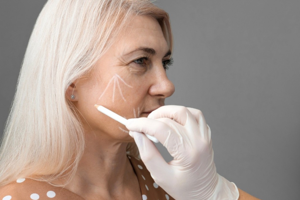 A mid-aged woman getting her face contoured for a facelift procedure.